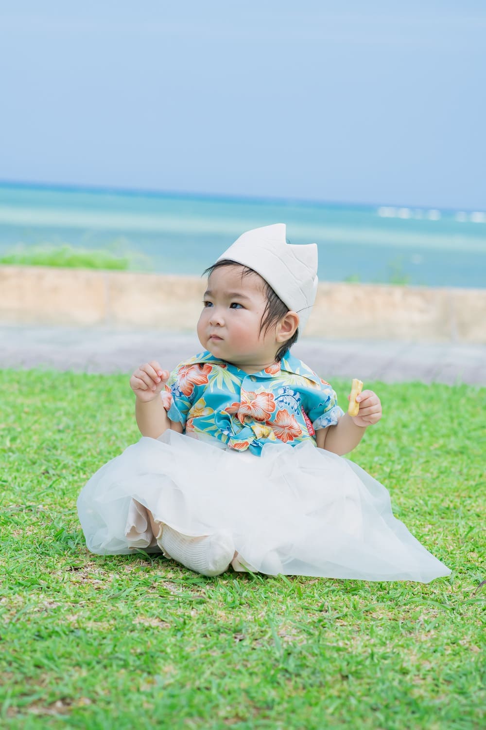 かりゆしシャツとふんわりスカートを合わせたベビーのソロショット