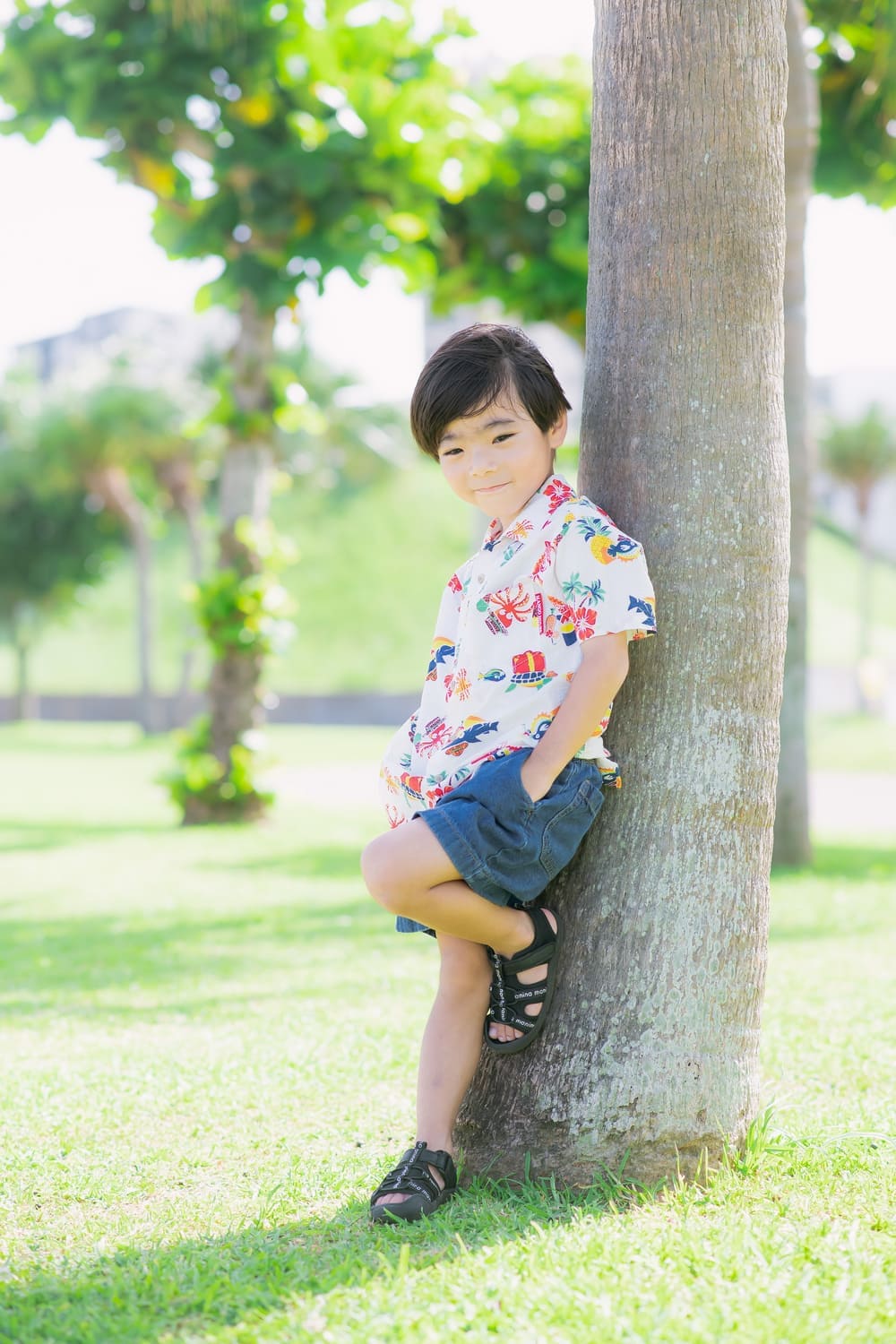 ヤシの木にもたれかかり少し大人びた表情を見せるお兄ちゃん