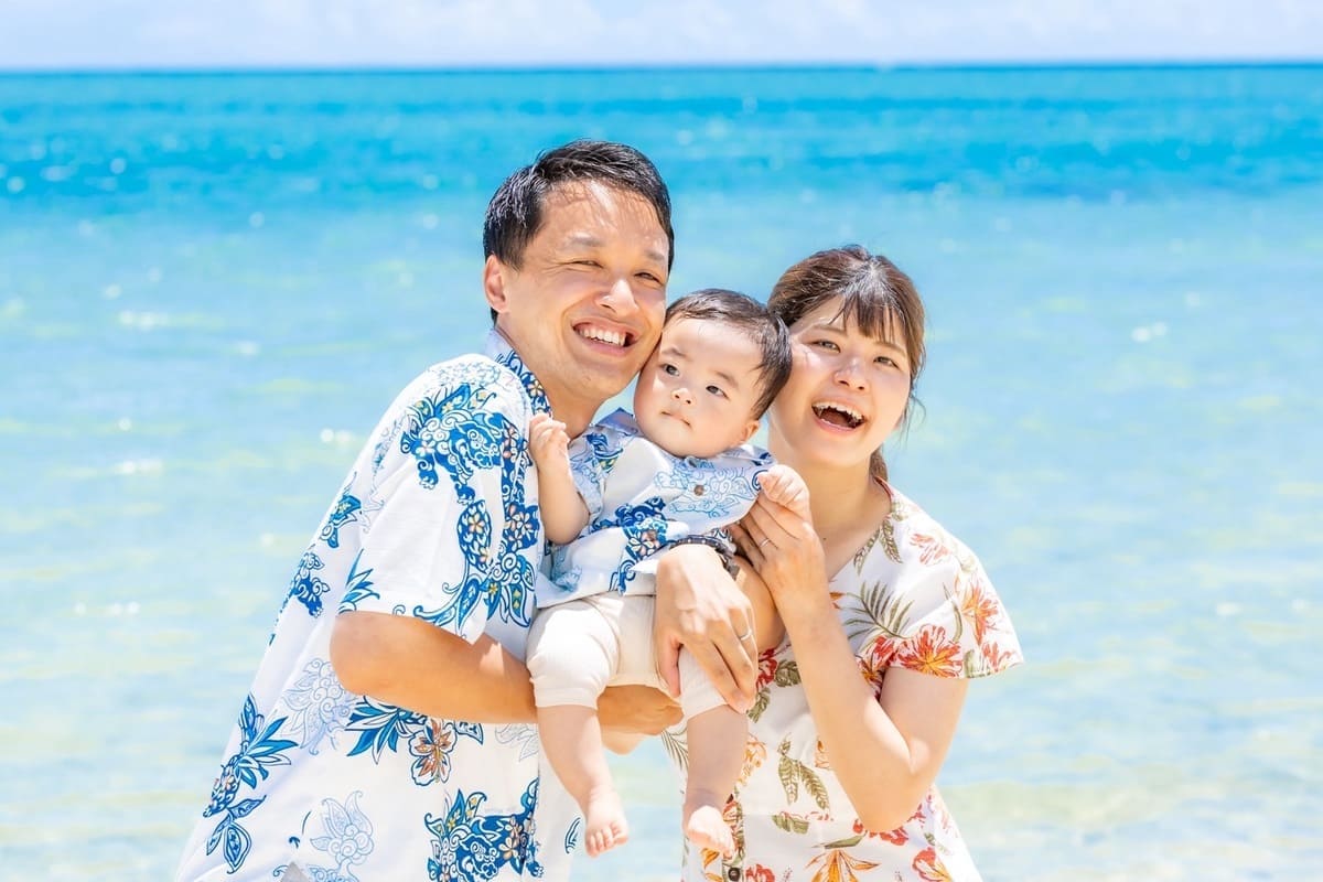 広い砂浜とエメラルドグリーンの海に囲まれた家族のロケーションフォト